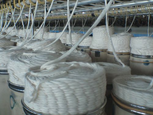 工厂里纺织工人和机械设备井然有序地进行工作,成品的粗纱